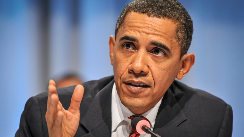 Barack Obama gesturing at microphone