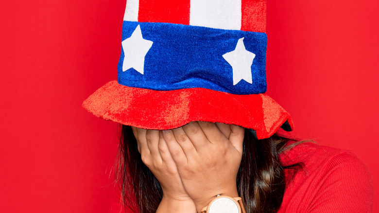 Patriotic woman hiding her face