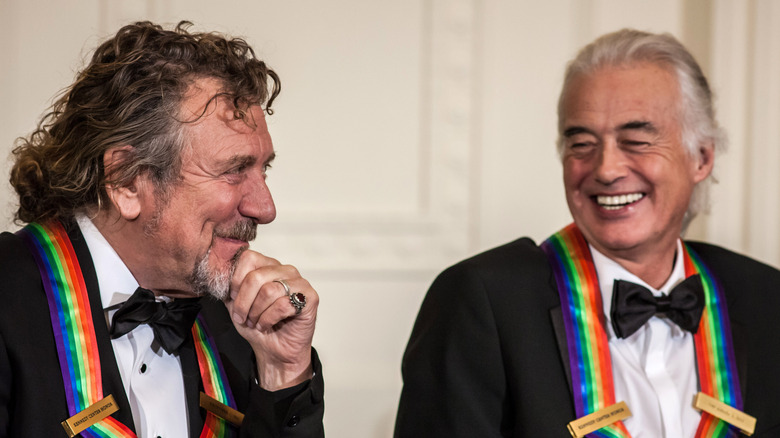 Robert Plant and Jimmy Page laughing wearing medals