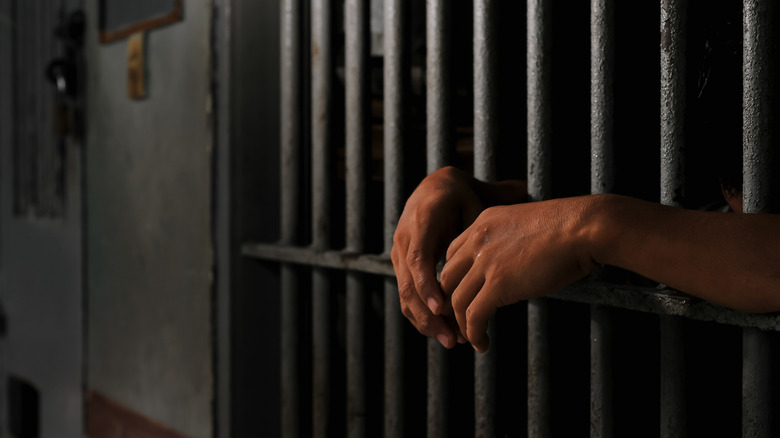 inmates hand leaning out of prison cell