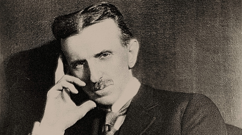 Nikola Tesla in suit and moustache leaning head on hand