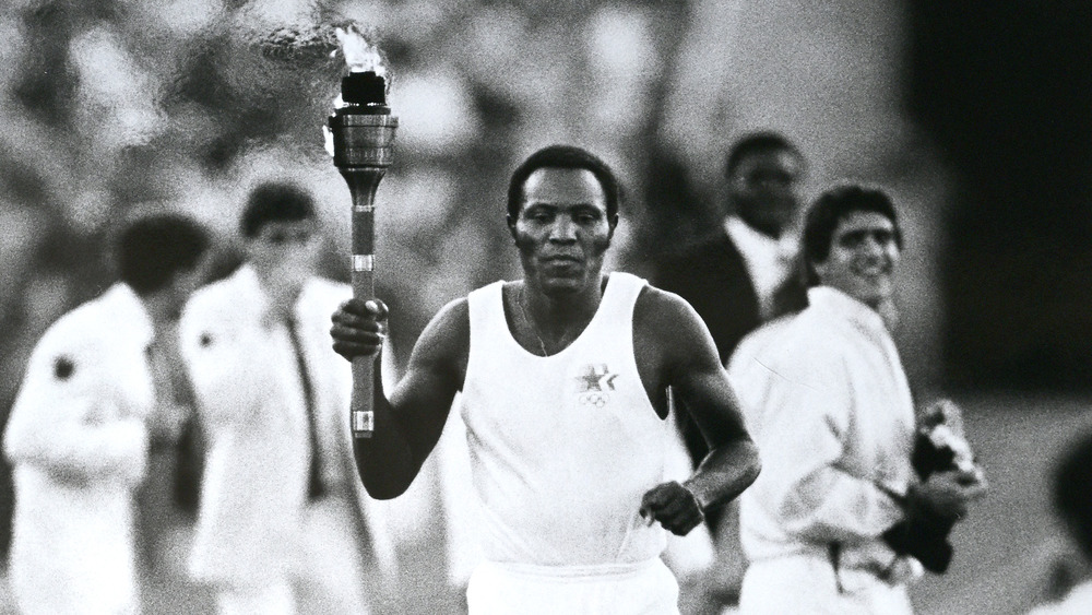 Former gold medalist in the decathlon, Rafer Johnson carries the torch on the final leg to to start the 1984 Summer Olympics at the Los Angeles Memorial Coliseum, Los Angeles, California.