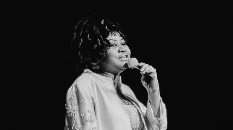 Aretha Franklin singing into microphone