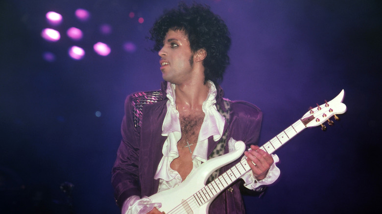 Prince playing guitar onstage during Purple Rain tour