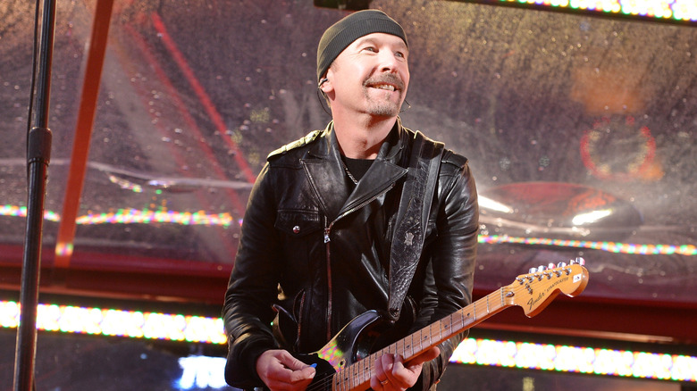 The Edge playing guitar to crowd