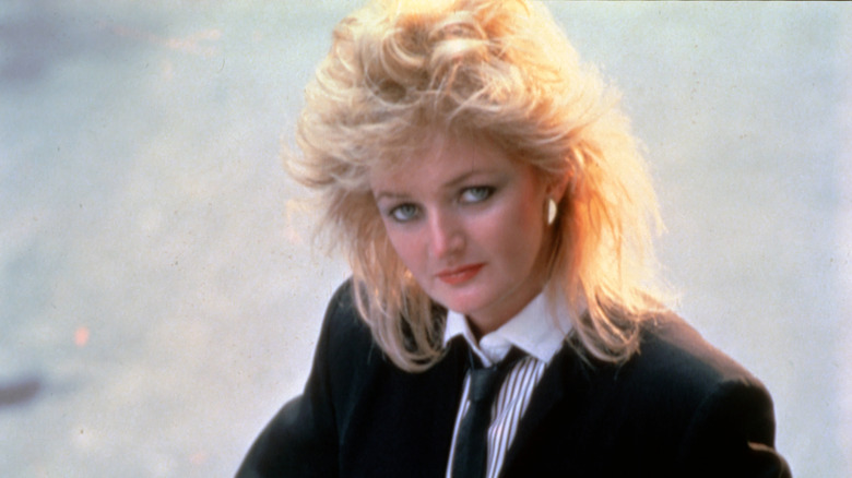 Bonnie Tyler with feathered hair in suit and tie