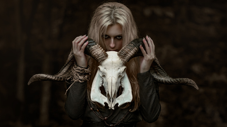 Girl holding a ram skull