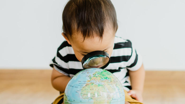 Toddler examines a globe