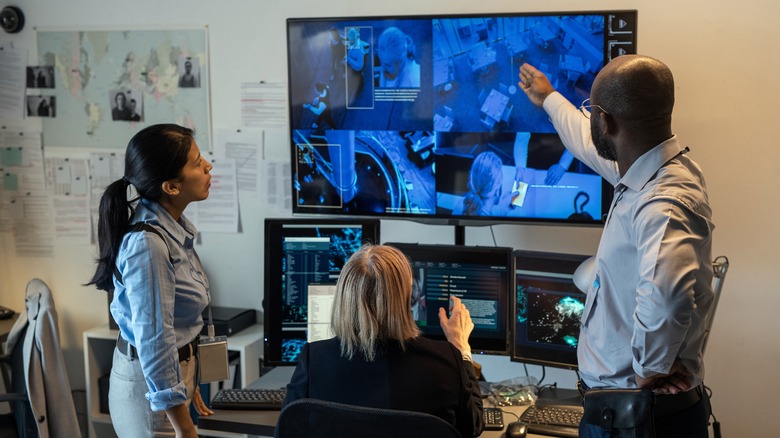 Team of police officers examining video evidence