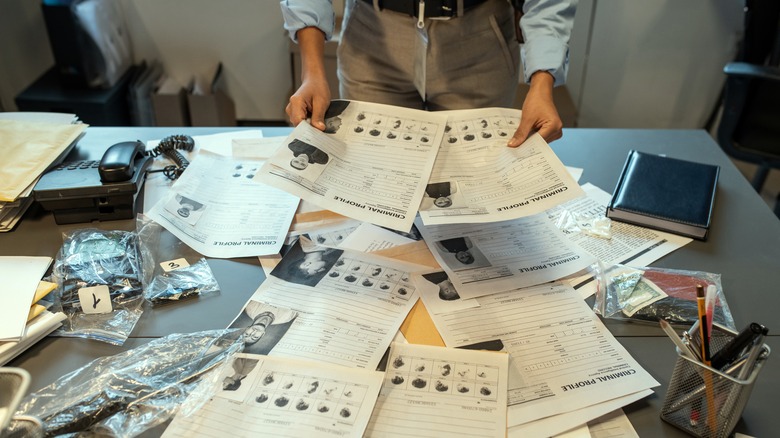 Police detective inspecting paperwork at desk
