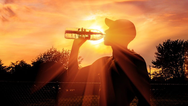 man drinking water heat wave during the summer
