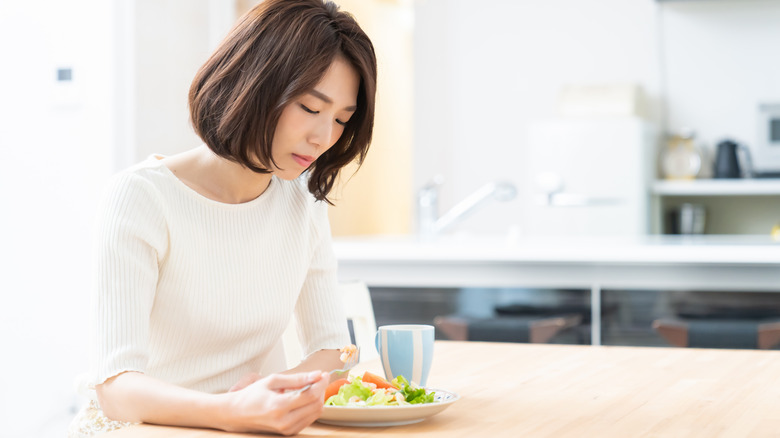 sad woman doesn't want to eat lunch