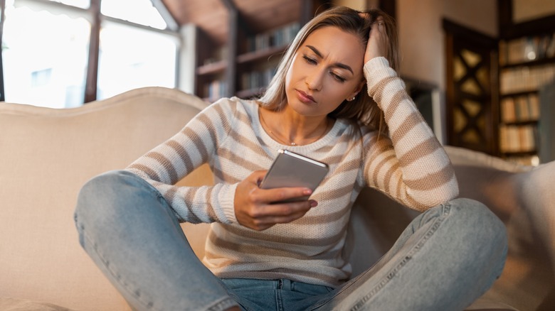 confused woman trying to use a smartphone