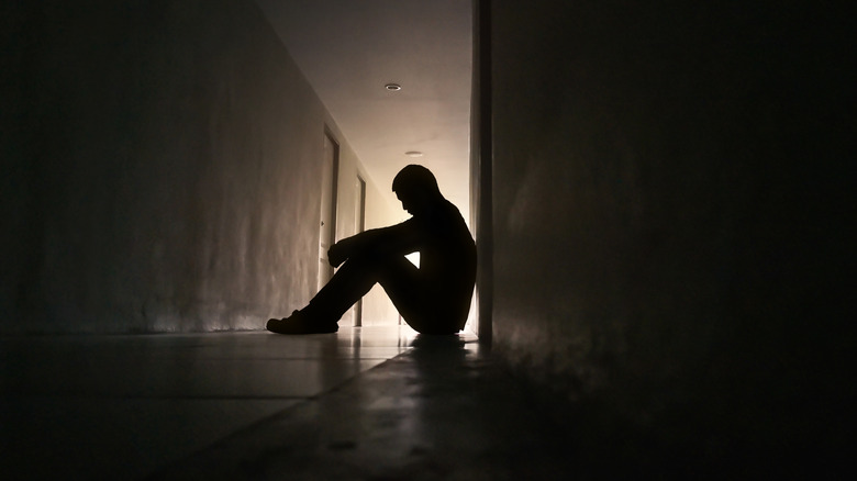 Depressed man sitting on floor