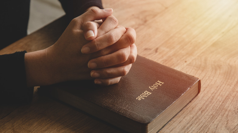 Praying hands over the Bible