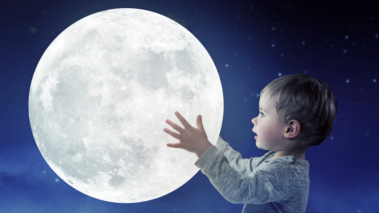 A baby holds the moon