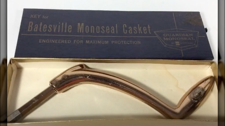 A brass casket key in its box with the lid open