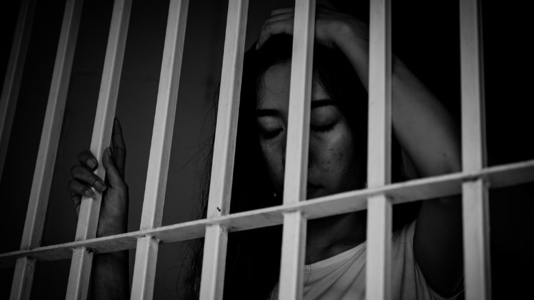 Asian woman behind bars