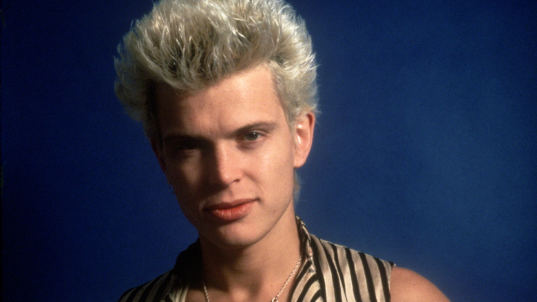 billy idol leering into camera wearing striped vest