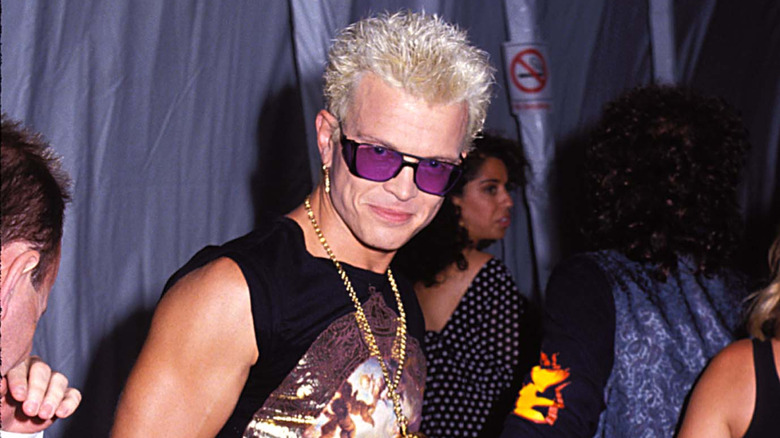 billy idol in purple sunglasses smiling at camera