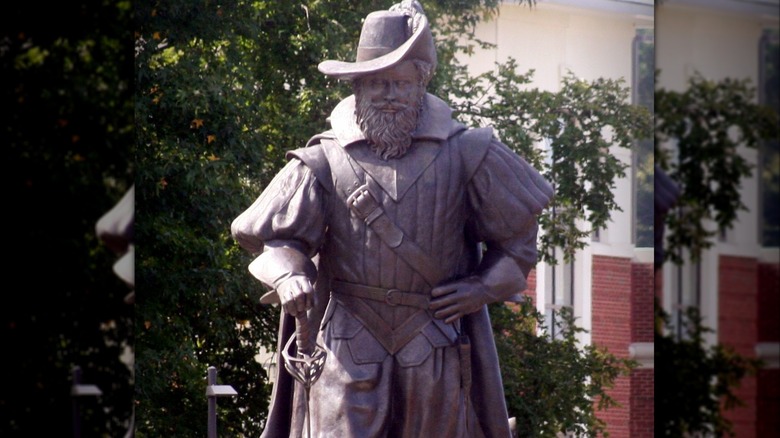 Statue of Christopher Newport wearing a hat and holding sword with other hand on hip