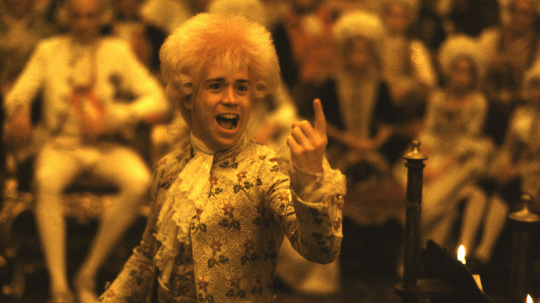 Tom Hulce as Wolfgang Amadeus Mozart laughing holding index finger up