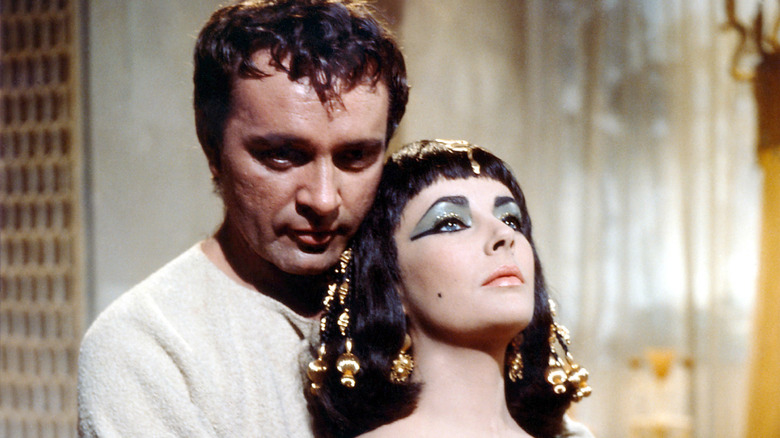 elizabeth taylor with heavy makeup being held by Richard Burton in cleopatra