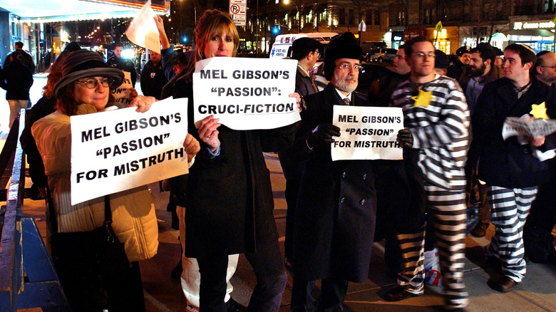 protestors of the passion of the christ holding placards in city