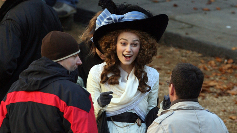 keira knightley laughing in costume and big hat for the duchess