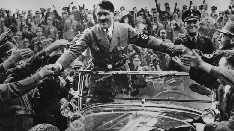 Adolf Hitler in a car surrounded by people