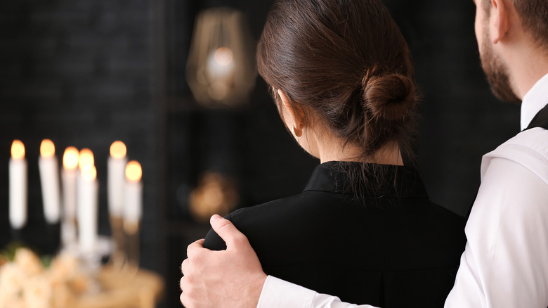 Couple comforting each other at funeral 