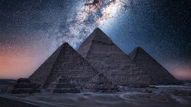 The Milky Way stretches behind the pyramids