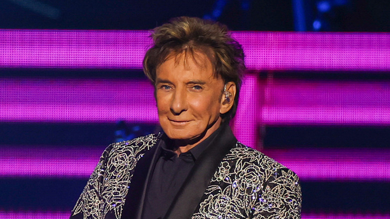 Barry Manilow smiling in sequined jacket on stage