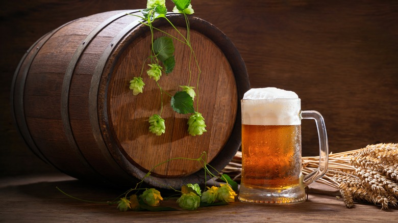 Foamy beer next to a barrel 