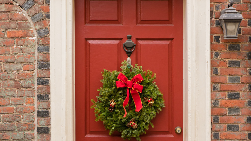 Colonial red doorway in historic Elfreth's Alley in Philadelphia with pediment and Christmas wreath.