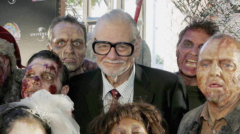 Romero posing with actors as zombies