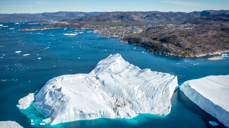 Iceberg floating in water with broken ice chunks