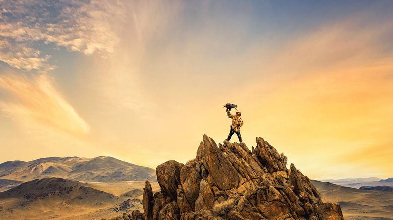 Mongolian traditional eagle hunter on cliff
