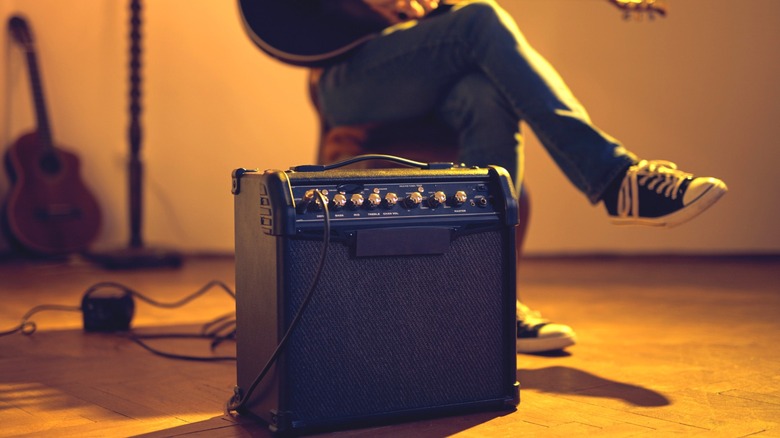 Guy sitting with guitar and amp
