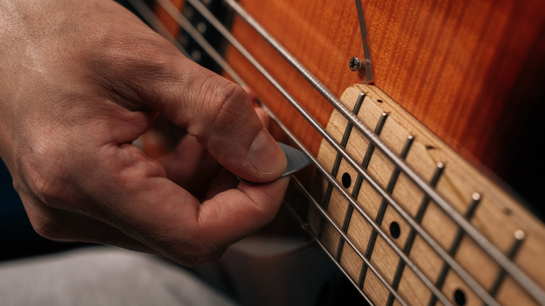 Close-up shot of a hand holding a guitar pick.