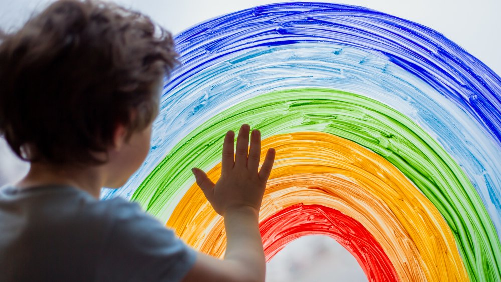 Kid painting a rainbow