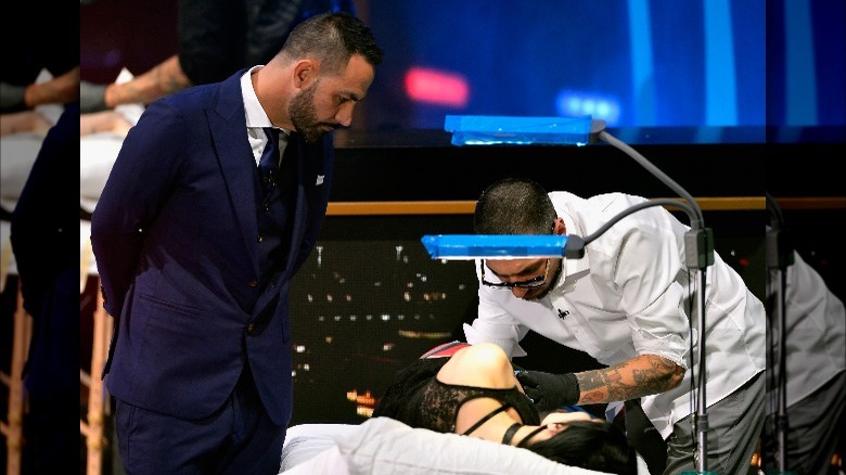Chris Nunez looking at tattoo artist