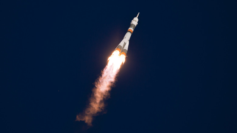 Rocket blasting into space with night sky