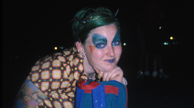 Woodstock 99 concertgoer in face paint sitting on ground