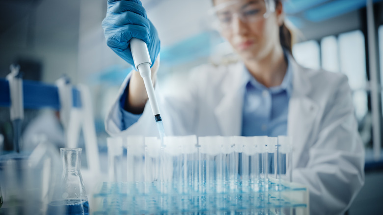researcher using pipette and test tubes