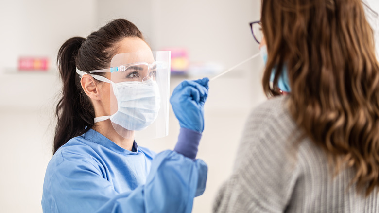 medical professional swabbing a patient's nose