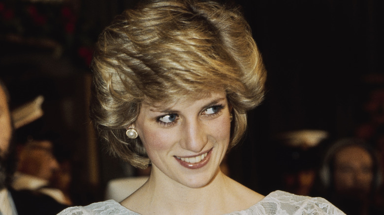 Prince Charles frowning and Princess Diana smiling 