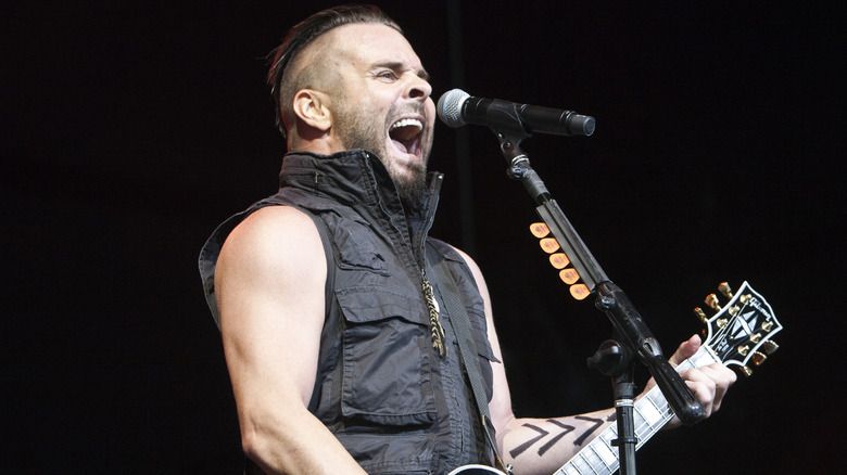 Chris Shinn singing into mic guitar