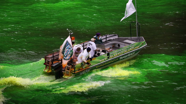 Workers dyeing river by boat