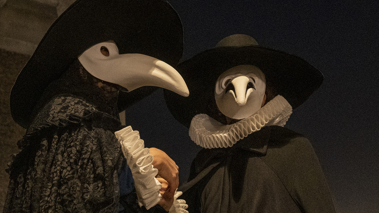 couple wearing plague doctor costumes